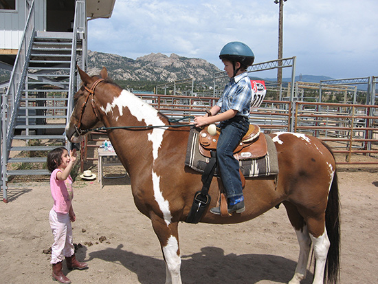 Kids riding horses safely.